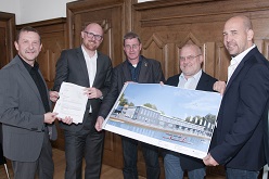 Die Baugenehmigung für das Bundes- und Landesleistungszentrum für den Kanurennsport in Duisburg wurde erteilt. Oberbürgermeister Sören Link (2. v.l.) überreicht dem Geschäftsführer von DuisburgSport, Jürgen Dietz (l.), das Dokument. Der stlv. Sportdezernent Thomas Kützberg, Jürgen Joachim, Präsident des Kanu-Regatta-Vereins Duisburg und Jens Karl, Trainer des Bundesleistungszentrums präsentieren eine Skizze des Gebäudes nach dem Umbau.